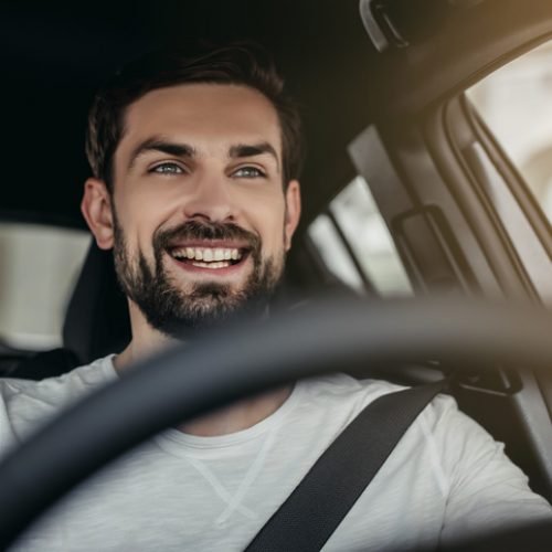 Man in car dealership Young man is choosing a new vehicle in car dealership.